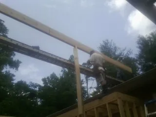 Carpenter setting a ridge beam over a new addition frame — Ice Dam Removal by Roofing Brothers in Burnsville