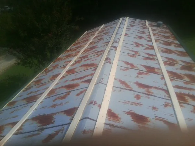 Rusted metal roof panels with new wood purlins before replacement — Storm Damage Roof Repair in Burnsville by Roofing Brothers
